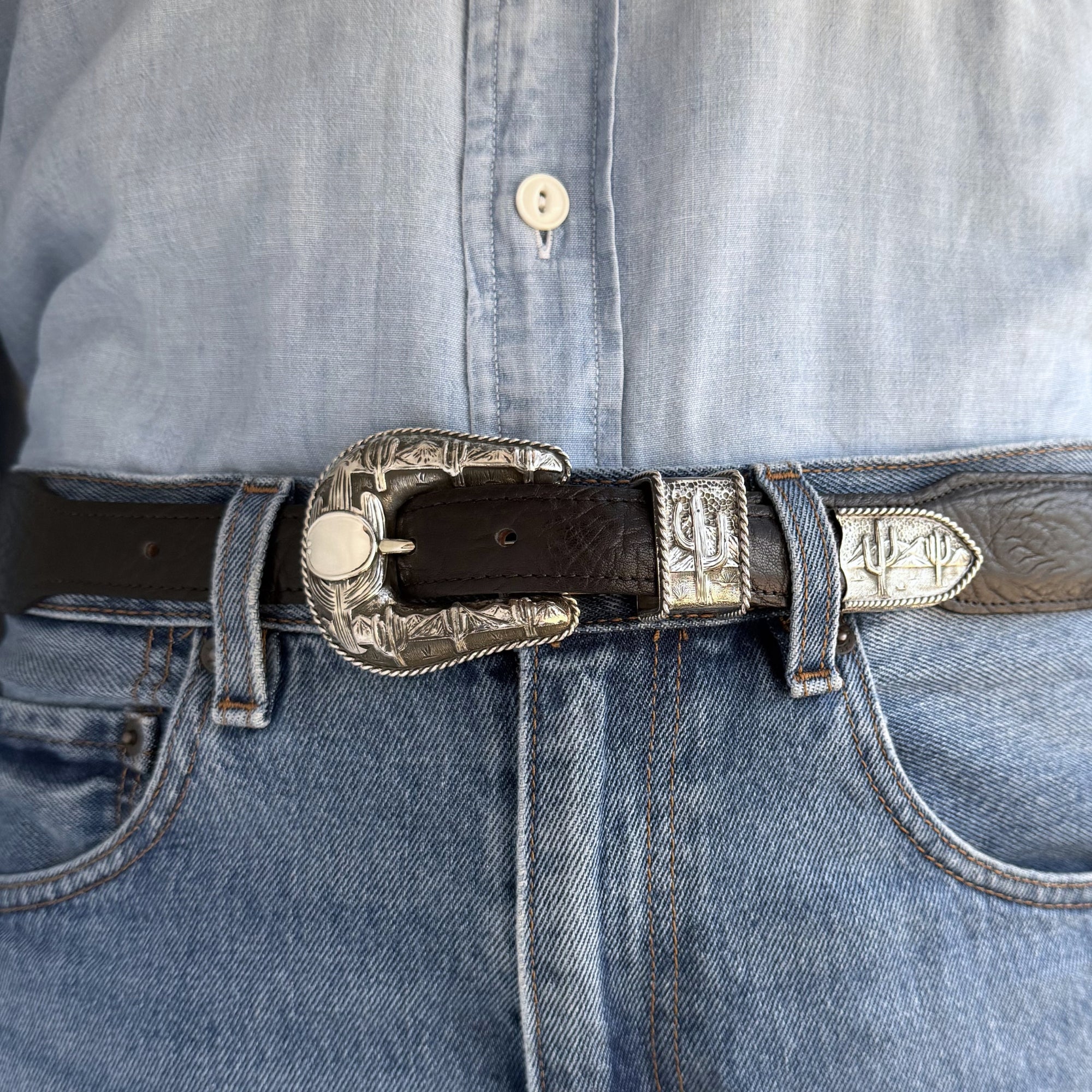 Close-up of a belt with decorative buckle on jeans