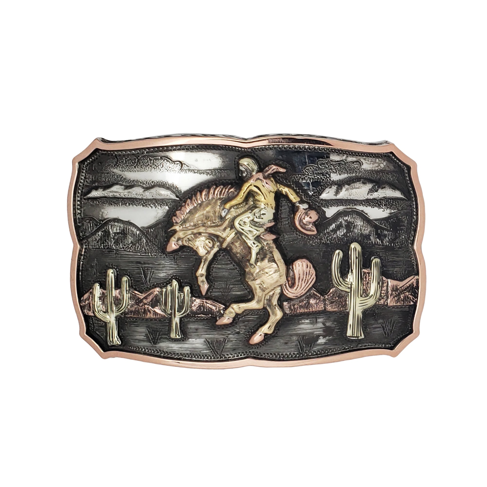 A western-themed belt buckle featuring a sculpted scene of a cowboy riding a bucking horse across a desert landscape with cacti and mountains. The buckle has a dark textured background with a rose gold border and highlights.