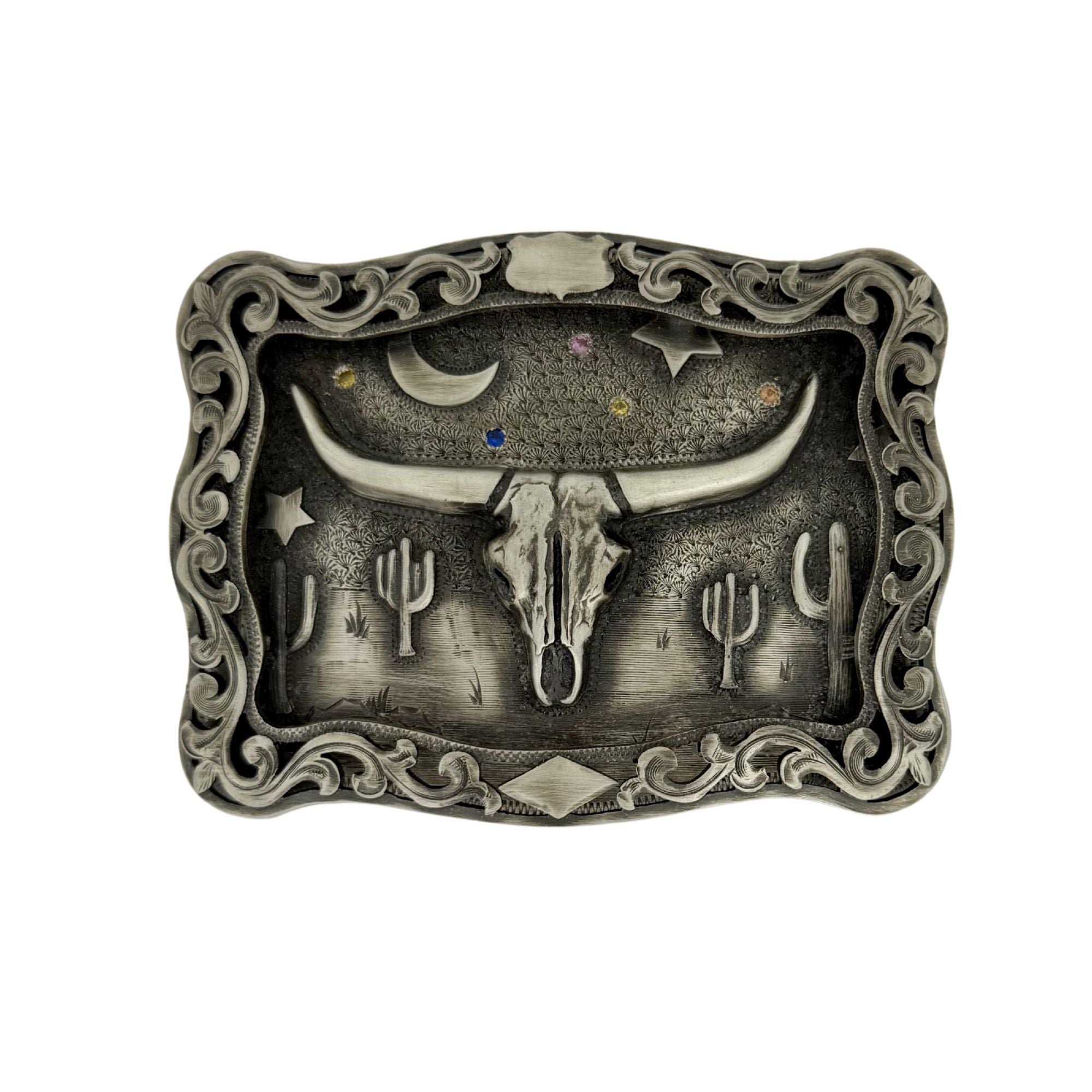 Decorative belt buckle with longhorn skull, cacti, and celestial design on a white background