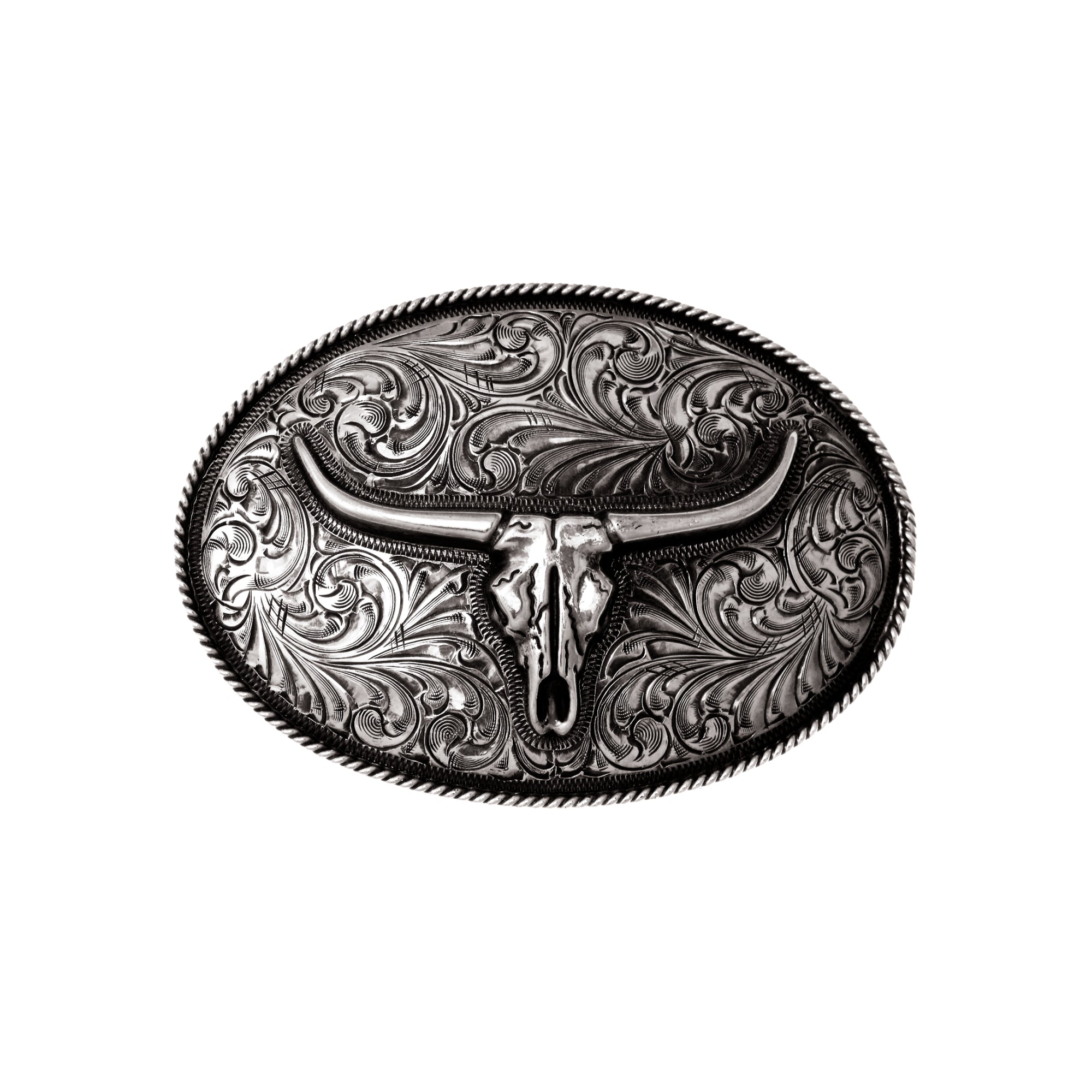 An oval silver buckle featuring an overlaid skull  with hand engraving and a twisted rope edge.