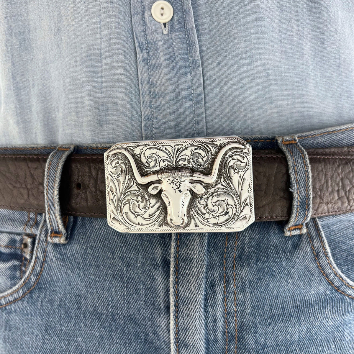 Bohlin 466 Steer sterling silver Longhorn belt buckle worn on a brown leather belt with jeans.