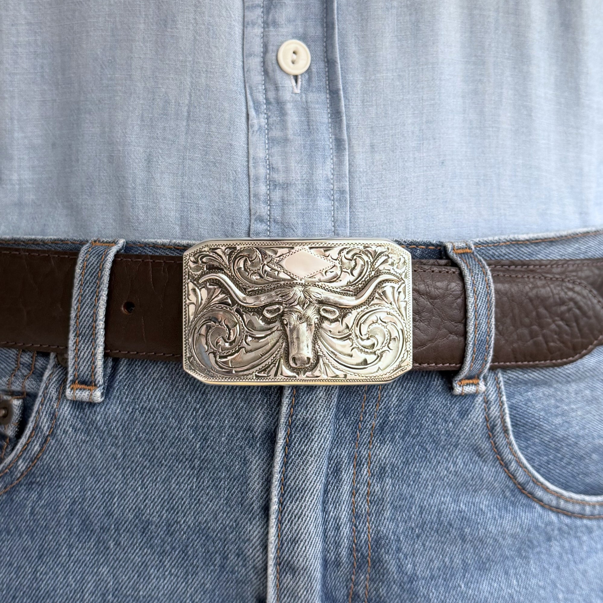 Rectangle engraved Bohlin longhorn buckle on brown belt. 