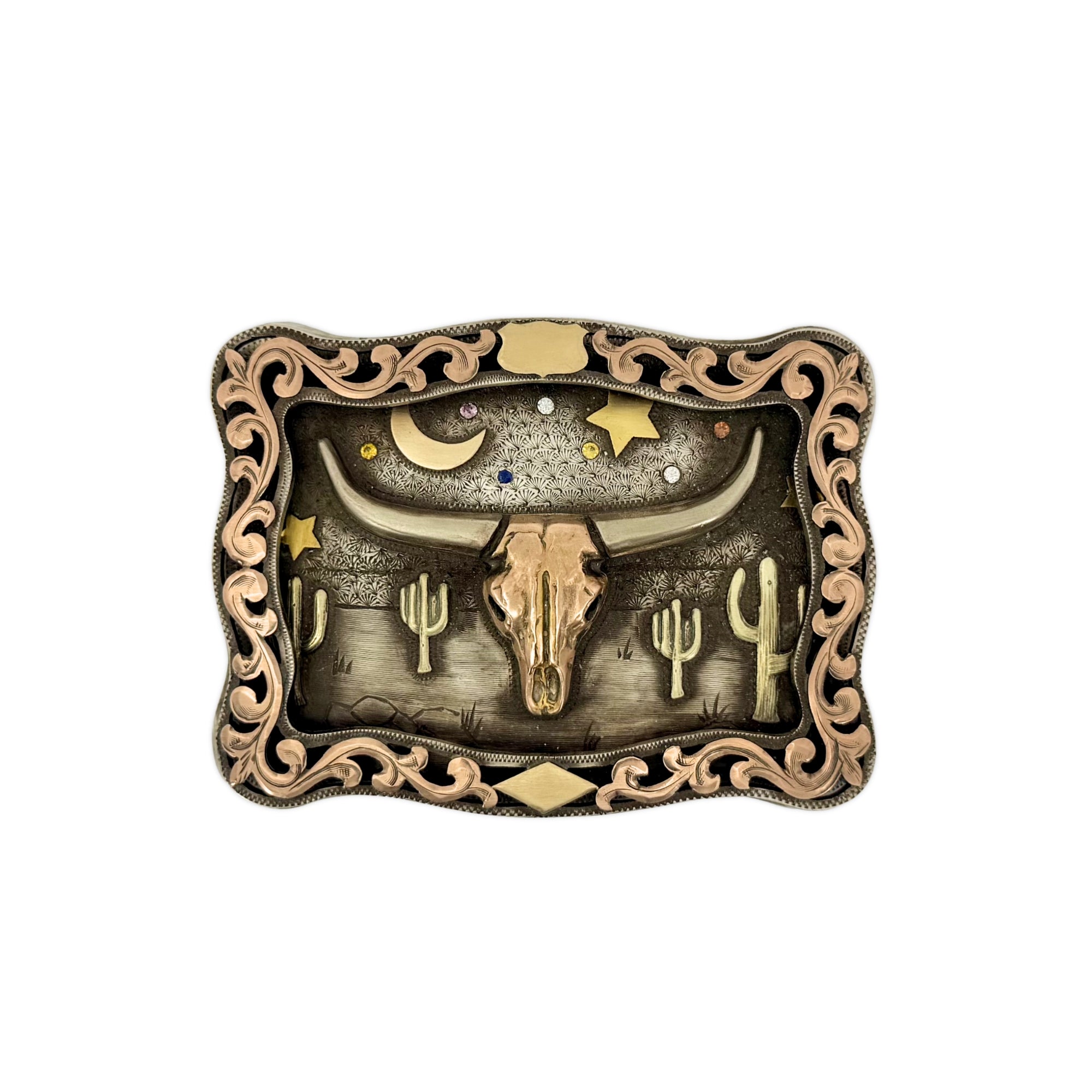 Decorative Bohlin belt buckle with longhorn skull, stars, and cacti design on an engraved background