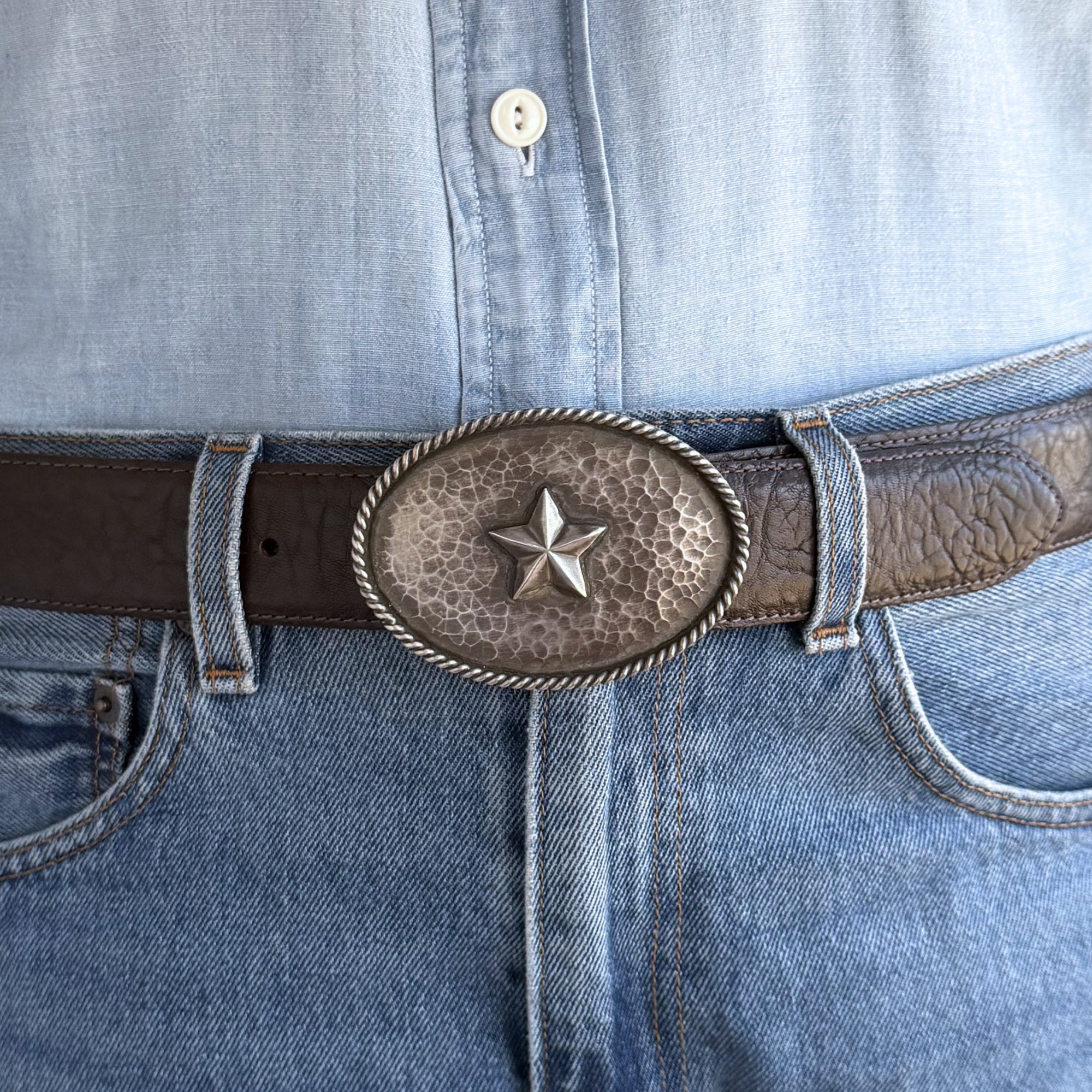 Sterling silver antiqued oval belt buckle wiith 5 pointed star and hand twisted rope edge on brown belt. 